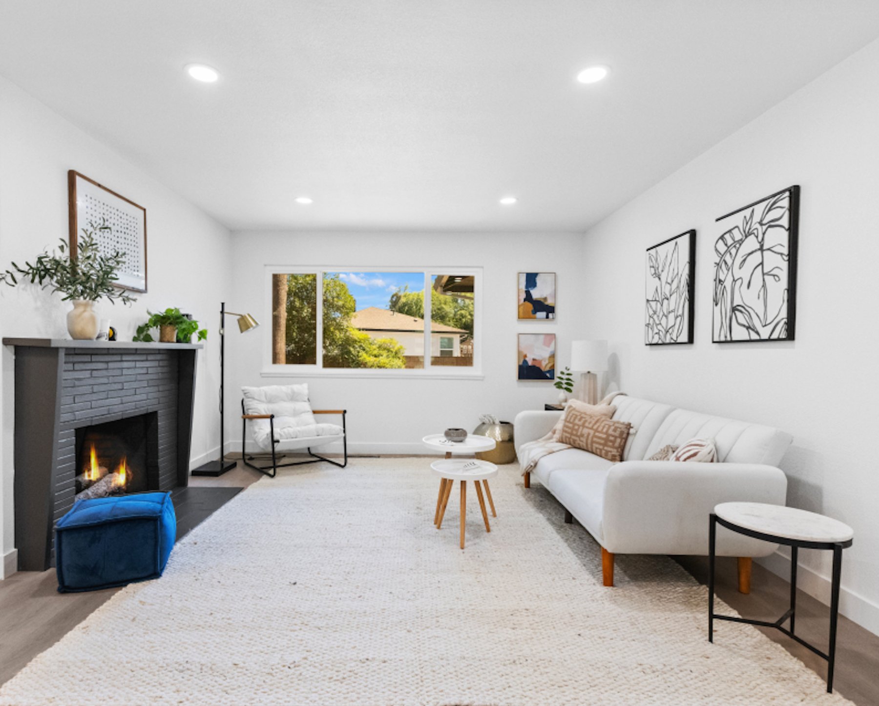 A finished, staged living room with a charcoal brick fireplace